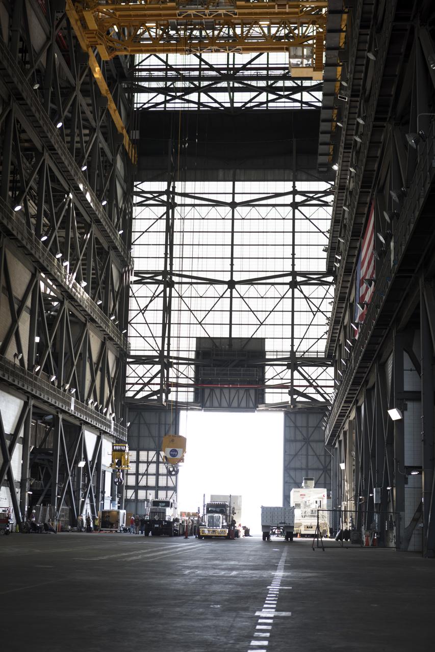 The ground test motor for Orion's Launch Abort System (LAS) arrives by flatbed truck in its shipping container in the transfer aisle of the Vehicle Assembly Building on July 20, 2018, at NASA's Kennedy Space Center in Florida. It will be transferred to the Rotation, Processing and Surge Facility where it will be inspected and prepared for transport to Space Launch Complex 46 (SLC-46) at Cape Canaveral Air Force Station for mechanical fit testing. This inert motor will not be used for flight, but will be used to certify flight hardware assembly in preparation for a full-stress test of the LAS, called Ascent Abort-2 (AA-2) flight test, scheduled for April 2019. During the test, the booster will launch from SLC 46, carrying a fully functional LAS and a 22,000-pound Orion test vehicle to an altitude of 31,000 feet and traveling at more than 1,000 miles an hour. The test will verify the LAS can steer the crew module and astronauts aboard to safety in the event of an issue with the Space Launch System (SLS) rocket when the spacecraft is under the highest aerodynamic loads it will experience during a rapid climb into space. NASA's Orion and Exploration Ground Systems programs and their contractors from Jacob's and Northrup Grumman in conjunction with the Air Force Space and Missile Center's Launch Operations branch are performing the pathfinding exercises and flight operations for AA-2.
