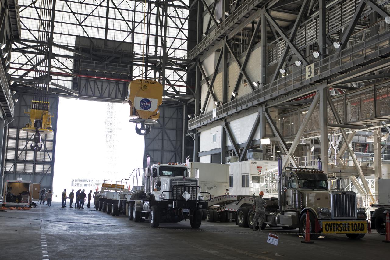 The ground test motor for Orion's Launch Abort System (LAS) arrives by flatbed truck in its shipping container in the transfer aisle of the Vehicle Assembly Building on July 20, 2018, at NASA's Kennedy Space Center in Florida. It will be transferred to the Rotation, Processing and Surge Facility where it will be inspected and prepared for transport to Space Launch Complex 46 (SLC-46) at Cape Canaveral Air Force Station for mechanical fit testing. This inert motor will not be used for flight, but will be used to certify flight hardware assembly in preparation for a full-stress test of the LAS, called Ascent Abort-2 (AA-2) flight test, scheduled for April 2019. During the test, the booster will launch from SLC 46, carrying a fully functional LAS and a 22,000-pound Orion test vehicle to an altitude of 31,000 feet and traveling at more than 1,000 miles an hour. The test will verify the LAS can steer the crew module and astronauts aboard to safety in the event of an issue with the Space Launch System (SLS) rocket when the spacecraft is under the highest aerodynamic loads it will experience during a rapid climb into space. NASA's Orion and Exploration Ground Systems programs and their contractors from Jacob's and Northrup Grumman in conjunction with the Air Force Space and Missile Center's Launch Operations branch SMC/LEXO, are performing the pathfinding exercises and flight operations for AA-2.