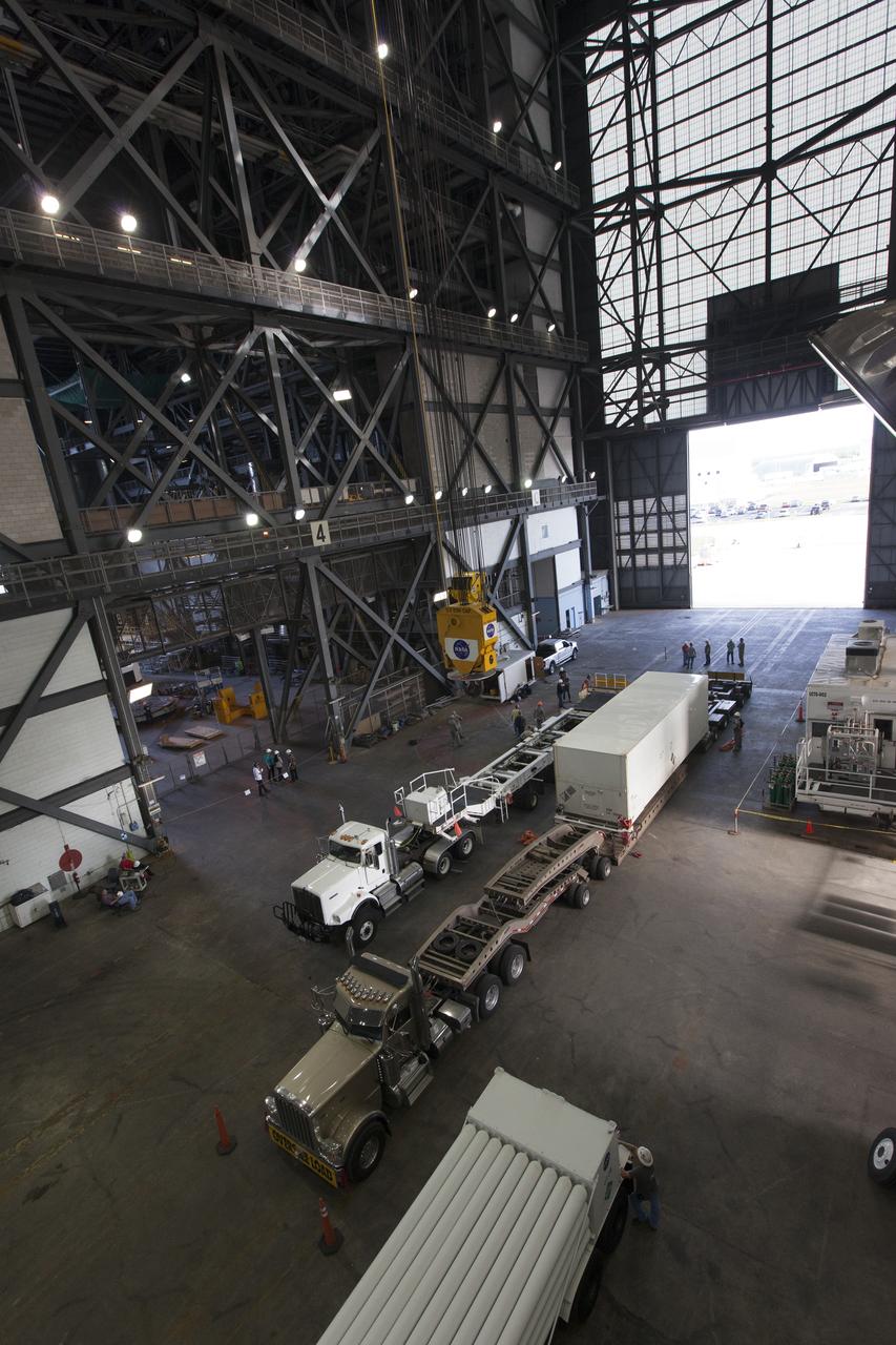 The ground test motor for Orion's Launch Abort System (LAS) arrives by flatbed truck in its shipping container in the transfer aisle of the Vehicle Assembly Building on July 20, 2018, at NASA's Kennedy Space Center in Florida. It will be transferred to the Rotation, Processing and Surge Facility where it will be inspected and prepared for transport to Space Launch Complex 46 (SLC-46) at Cape Canaveral Air Force Station for mechanical fit testing. This inert motor will not be used for flight, but will be used to certify flight hardware assembly in preparation for a full-stress test of the LAS, called Ascent Abort-2 (AA-2) flight test, scheduled for April 2019. During the test, the booster will launch from SLC 46, carrying a fully functional LAS and a 22,000-pound Orion test vehicle to an altitude of 31,000 feet and traveling at more than 1,000 miles an hour. The test will verify the LAS can steer the crew module and astronauts aboard to safety in the event of an issue with the Space Launch System (SLS) rocket when the spacecraft is under the highest aerodynamic loads it will experience during a rapid climb into space. NASA's Orion and Exploration Ground Systems programs and their contractors from Jacob's and Northrup Grumman in conjunction with the Air Force Space and Missile Center's Launch Operations branch SMC/LEXO, are performing the pathfinding exercises and flight operations for AA-2.