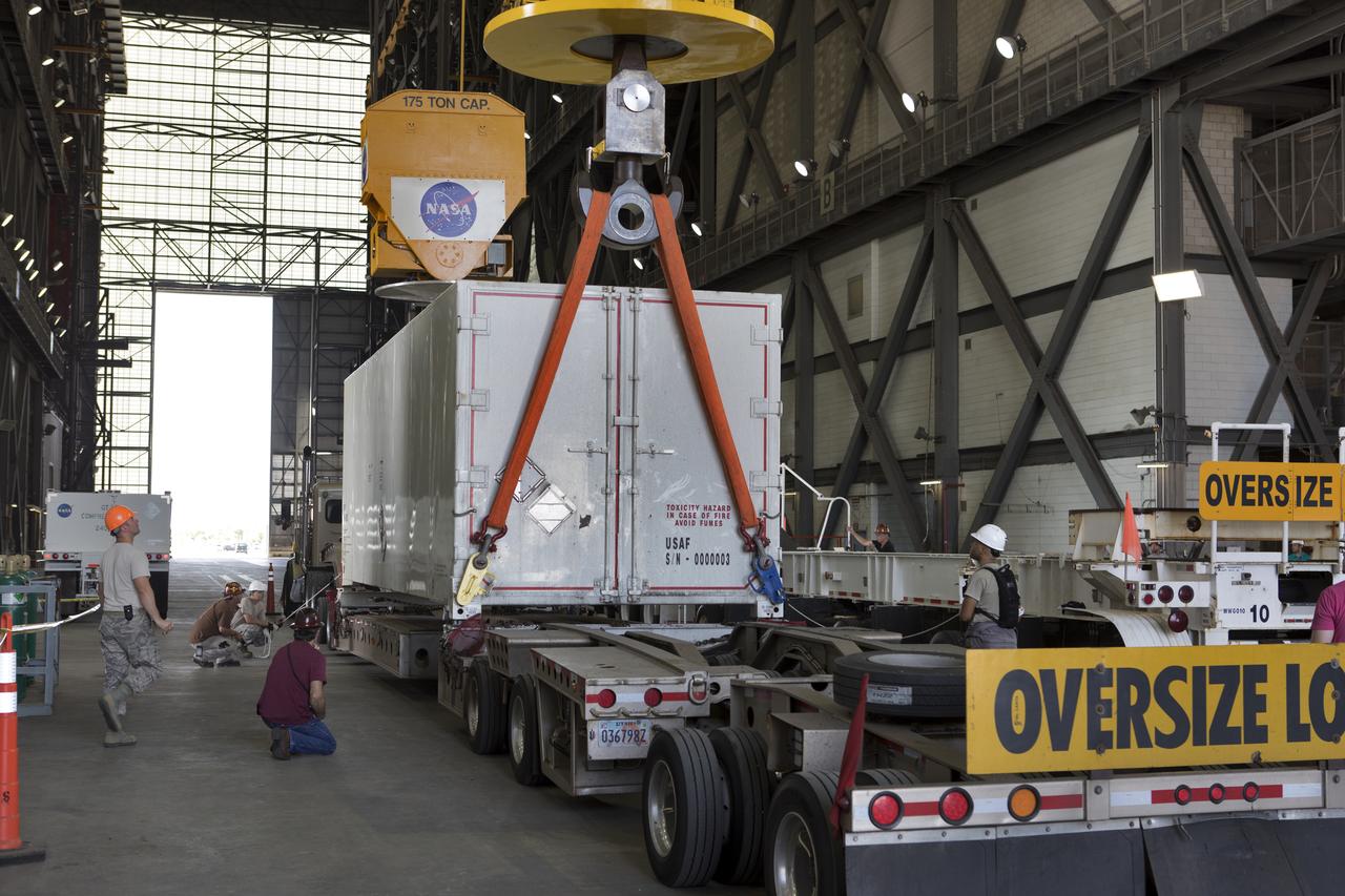 In the transfer aisle inside the Vehicle Assembly Building (VAB) at NASA's Kennedy Space Center in Florida, Jacob’s technicians attach a crane to a shipping container with the ground test motor for Orion's Launch Abort System (LAS) inside on July 20, 2018. The container will be lifted and transferred to another transporter and moved to the Rotation, Processing and Surge Facility where it will be inspected and prepared for transport to Space Launch Complex 46 (SLC-46) at Cape Canaveral Air Force Station for mechanical fit testing. This inert motor will not be used for flight, but will be used to certify flight hardware assembly in preparation for a full-stress test of the LAS, called Ascent Abort-2 (AA-2) flight test, scheduled for April 2019. During the test, the booster will launch from SLC 46, carrying a fully functional LAS and a 22,000-pound Orion test vehicle to an altitude of 31,000 feet and traveling at more than 1,000 miles an hour. The test will verify the LAS can steer the crew module and astronauts aboard to safety in the event of an issue with the Space Launch System (SLS) rocket when the spacecraft is under the highest aerodynamic loads it will experience during a rapid climb into space. NASA's Orion and Exploration Ground Systems programs and their contractors from Jacob's and Northrup Grumman in conjunction with the Air Force Space and Missile Center's Launch Operations branch SMC/LEXO, are performing the pathfinding exercises and flight operations for AA-2.