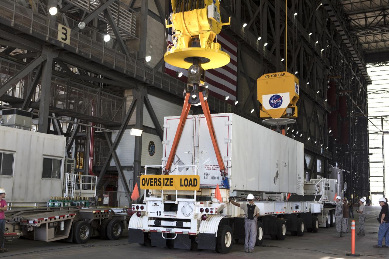 In the transfer aisle inside the Vehicle Assembly Building (VAB) at NASA's Kennedy Space Center in Florida, a crane lowers the shipping container with the ground test motor for Orion's Launch Abort System (LAS) inside onto another transporter on July 20, 2018. The container will be moved to the Rotation, Processing and Surge Facility where it will be inspected and prepared for transport to Space Launch Complex 46 (SLC-46) at Cape Canaveral Air Force Station for mechanical fit testing. This inert motor will not be used for flight, but will be used to certify flight hardware assembly in preparation for a full-stress test of the LAS, called Ascent Abort-2 (AA-2) flight test, scheduled for April 2019. During the test, the booster will launch from SLC 46, carrying a fully functional LAS and a 22,000-pound Orion test vehicle to an altitude of 31,000 feet and traveling at more than 1,000 miles an hour. The test will verify the LAS can steer the crew module and astronauts aboard to safety in the event of an issue with the Space Launch System (SLS) rocket when the spacecraft is under the highest aerodynamic loads it will experience during a rapid climb into space. NASA's Orion and Exploration Ground Systems programs and their contractors from Jacob's and Northrup Grumman in conjunction with the Air Force Space and Missile Center's Launch Operations branch SMC/LEXO, are performing the pathfinding exercises and flight operations for AA-2.