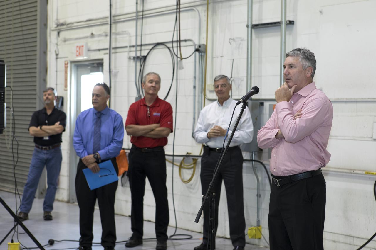 The team that tested the umbilical lines and accessories that will connect from the mobile launcher to NASA's Space Launch System rocket and Orion spacecraft for Exploration Mission-1 hold a banner signing event July 24, 2018, to mark completion of testing at the Launch Equipment Test Facility (LETF) at NASA's Kennedy Space Center in Florida. Speaking at the event is Scott Colloredo, far right, deputy director of Engineering. Next to him, from left, are Shawn Quinn, director of Engineering. Russ Deloach, director of Safety and Mission Assurance; and Andy Allen, program manager for Jacobs TOSC. A total of 21 umbilicals and launch accessories were tested on various simulators at the LETF before they were transferred to the mobile launcher for installation.