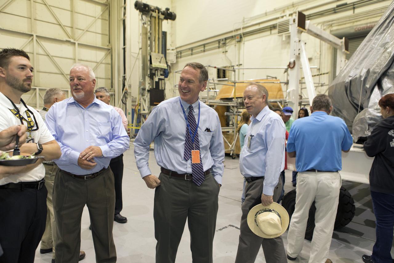 The team that tested the umbilical lines and accessories that will connect from the mobile launcher to NASA's Space Launch System rocket and Orion spacecraft for Exploration Mission-1 hold a banner signing event July 24, 2018, to mark completion of testing at the Launch Equipment Test Facility (LETF) at NASA's Kennedy Space Center in Florida. Attending the event is Mike Bolger, center, Exploration Ground Systems manager. A total of 21 umbilicals and launch accessories were tested on various simulators at the LETF before they were transferred to the mobile launcher for installation.