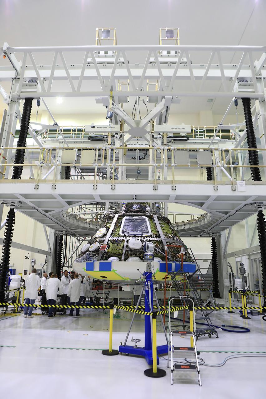 Lockheed Martin engineers and technicians are installing the heat shield to the Orion crew module July 25, 2018, inside the Neil Armstrong Operations and Checkout Building high bay at NASA's Kennedy Space Center in Florida. Orion is being prepared for Exploration Mission-1 (EM-1). The Orion spacecraft will launch atop NASA's Space Launch System rocket on its first uncrewed integrated flight. The heat shield will need to withstand temperatures of up to 5,000 degrees Fahrenheit during Orion's descent and re-entry through the Earth's atmosphere before it splashes down in the Pacific Ocean.