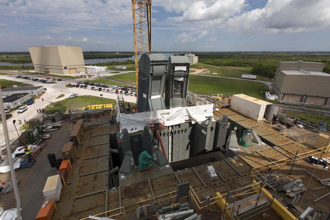 The second of two Tail Service Mast Umbilicals (TSMU), at left, is lowered for installation on the 0-level deck of the mobile launcher on July 27, at NASA's Kennedy Space Center in Florida. The 35-foot-tall umbilical will connect to NASA's Space Launch System (SLS) rocket core stage aft section and provide liquid hydrogen and electrical cable connections to the core stage engine section to support propellant handling during prelaunch operations. In view at right is the TSMU that will provide liquid oxygen and electrical cable connections to the core stage engine section. The installation brings Exploration Ground Systems one step closer to supporting prelaunch operations for the agency's SLS rocket and Orion spacecraft on Exploration Mission-1 and deep space destinations.