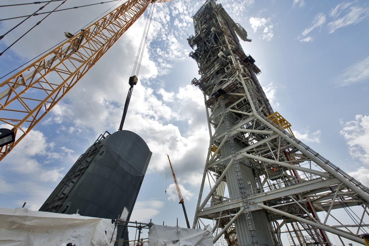 The second of two Tail Service Mast Umbilicals is lowered by crane for installation on the 0-level deck of the mobile launcher on July 27, at NASA's Kennedy Space Center in Florida. The 35-foot-tall umbilical will connect to NASA's Space Launch System (SLS) rocket core stage aft section and provide liquid hydrogen and electrical cable connections to the core stage engine section to support propellant handling during prelaunch operations. The installation brings Exploration Ground Systems one step closer to supporting prelaunch operations for the agency's SLS rocket and Orion spacecraft on Exploration Mission-1 and deep space destinations.