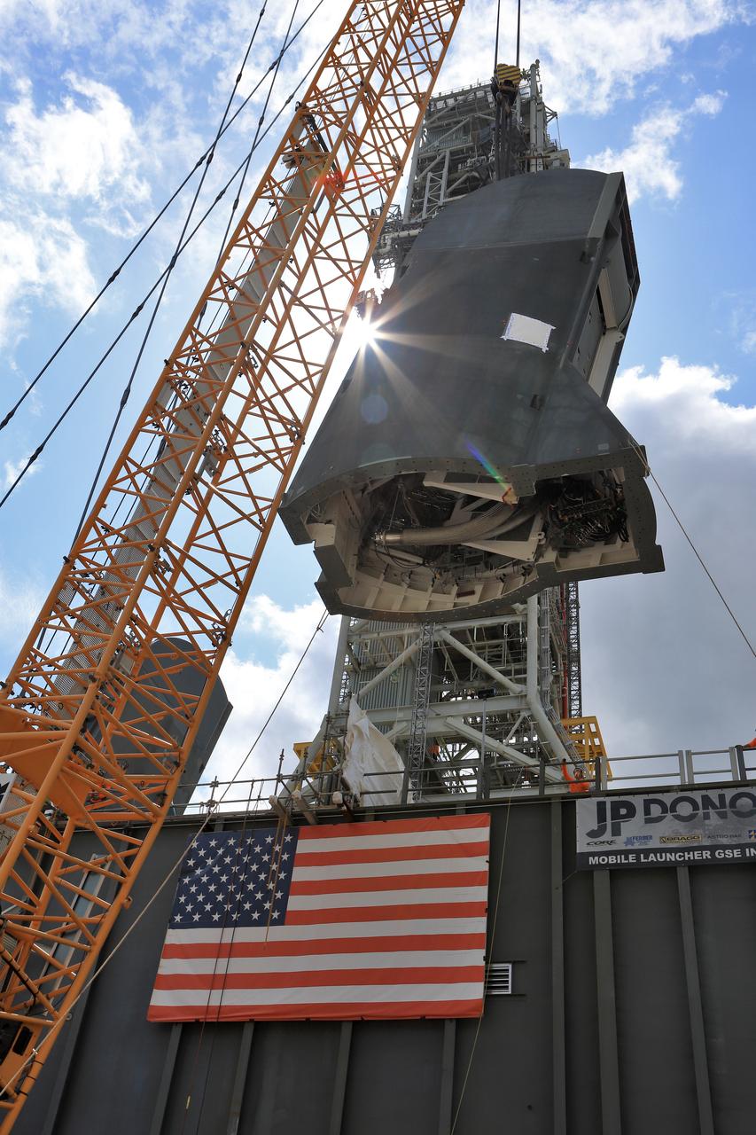 The second of two Tail Service Mast Umbilicals is lifted by crane for installation on the 0-level deck of the mobile launcher on July 27, at NASA's Kennedy Space Center in Florida. The 35-foot-tall umbilical will connect to NASA's Space Launch System (SLS) rocket core stage aft section and provide liquid hydrogen and electrical cable connections to the core stage engine section to support propellant handling during prelaunch operations. The installation brings Exploration Ground Systems one step closer to supporting prelaunch operations for the agency's SLS rocket and Orion spacecraft on Exploration Mission-1 and deep space destinations.