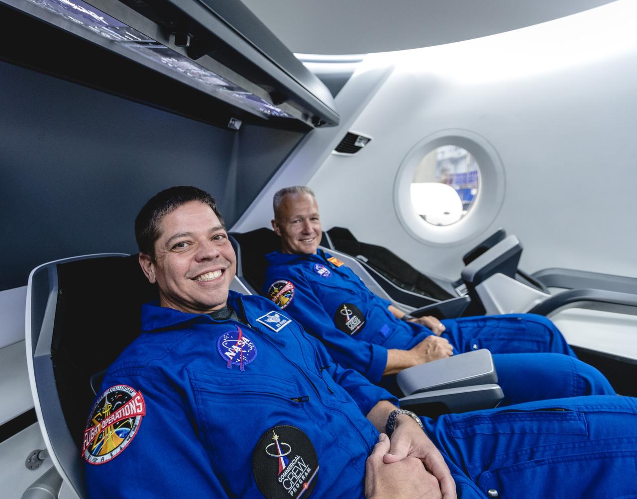 NASA astronauts, from left, Bob Behnken and Doug Hurley, assigned to fly on SpaceX's Demo-2  test flight of its Crew Dragon, are inside a mockup of the spacecraft at NASA's Johnson Space Center in Houston on Aug. 2, 2018, ahead of the agency's announcement of their commercial crew assignment Aug. 3. Nine U.S. astronauts were selected for commercial crew flight assignments on the first test flights and operational missions for SpaceX's Crew Dragon and Boeing's CST-100 Starliner.