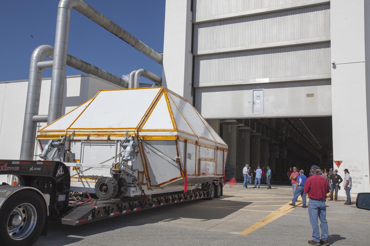 The Orion crew module pressure vessel for Exploration Mission-2 arrives at the Neil Armstrong Operations and Checkout Building at NASA's Kennedy Space Center in Florida on Aug. 24, 2018. The pressure vessel was transported in its Crew Module Transportation Fixture by super-wide transport truck from Michoud Assembly Facility near New Orleans. The pressure vessel is Orion's primary structure that holds the pressurized atmosphere astronauts will breathe and work in while in the vacuum of deep space. It will be moved into the facility's high bay, where it will be secured on a precision alignment tool to begin preparing it for flight.