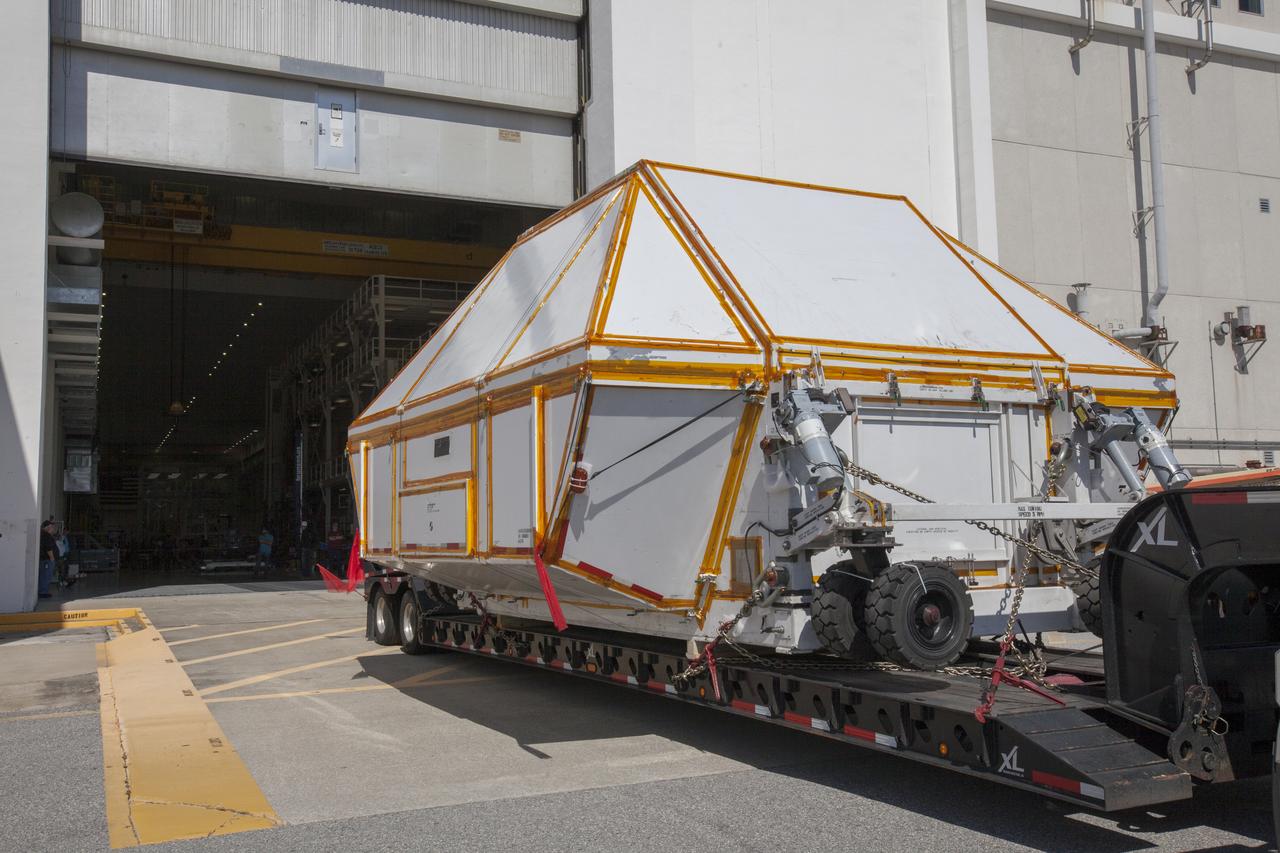 The Orion crew module pressure vessel for Exploration Mission-2 arrives at the Neil Armstrong Operations and Checkout Building at NASA's Kennedy Space Center in Florida on Aug. 24, 2018. The pressure vessel was transported in its Crew Module Transportation Fixture by super-wide transport truck from Michoud Assembly Facility near New Orleans. The pressure vessel is Orion's primary structure that holds the pressurized atmosphere astronauts will breathe and work in while in the vacuum of deep space. It will be moved into the facility's high bay, where it will be secured on a precision alignment tool to begin preparing it for flight.