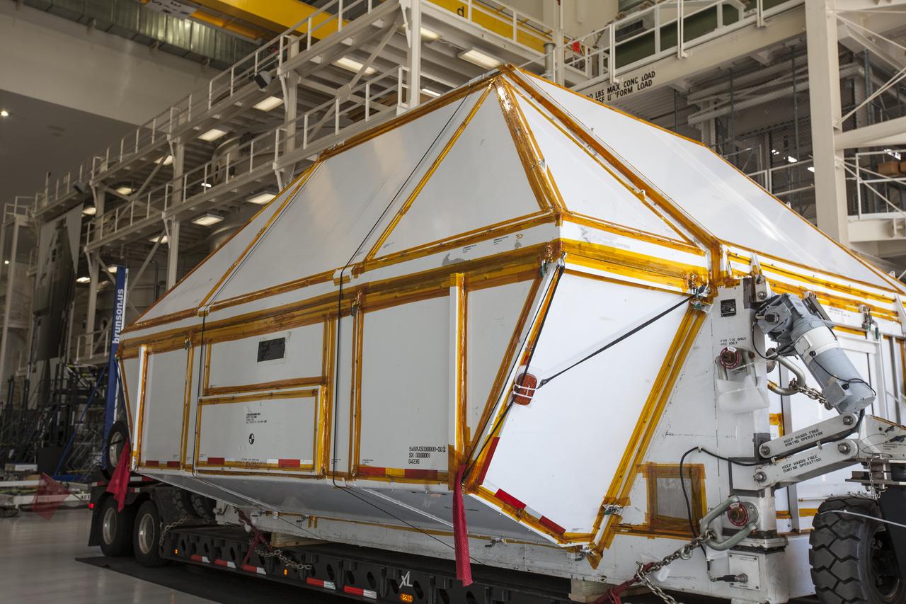 The Orion crew module pressure vessel for Exploration Mission-2 is backed into the high bay at the Neil Armstrong Operations and Checkout Building at NASA's Kennedy Space Center in Florida on Aug. 24, 2018. The pressure vessel was transported in its Crew Module Transportation Fixture by super-wide transport truck from Michoud Assembly Facility near New Orleans. The pressure vessel is Orion's primary structure that holds the pressurized atmosphere astronauts will breathe and work in while in the vacuum of deep space. Inside the facility's high bay, the pressure vessel will be secured on a precision alignment tool to begin preparing it for flight.