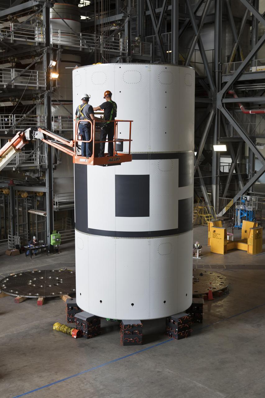 Technicians with Jacobs check the alignment during stacking of the aeroshells for Orion's Launch Abort System (LAS) in High Bay 4 of the Vehicle Assembly Building on Aug. 3, 2018, at NASA's Kennedy Space Center in Florida. The aeroshells are being prepared for a full-stress test of the LAS, called Ascent Abort-2 (AA-2) flight test, scheduled for April 2019. During the test, a booster will launch from Space Launch Complex 46 at Cape Canaveral Air Force Station, carrying a fully functional LAS and a 22,000-pound Orion test vehicle to an altitude of 31,000 feet and traveling at more than 1,000 miles an hour. The test will verify the LAS can steer the crew module and astronauts aboard to safety in the event of an issue with the Space Launch System (SLS) rocket when the spacecraft is under the highest aerodynamic loads it will experience during a rapid climb into space. Orion is being prepared for its first integrated uncrewed flight atop the SLS on Exploration Mission-1.