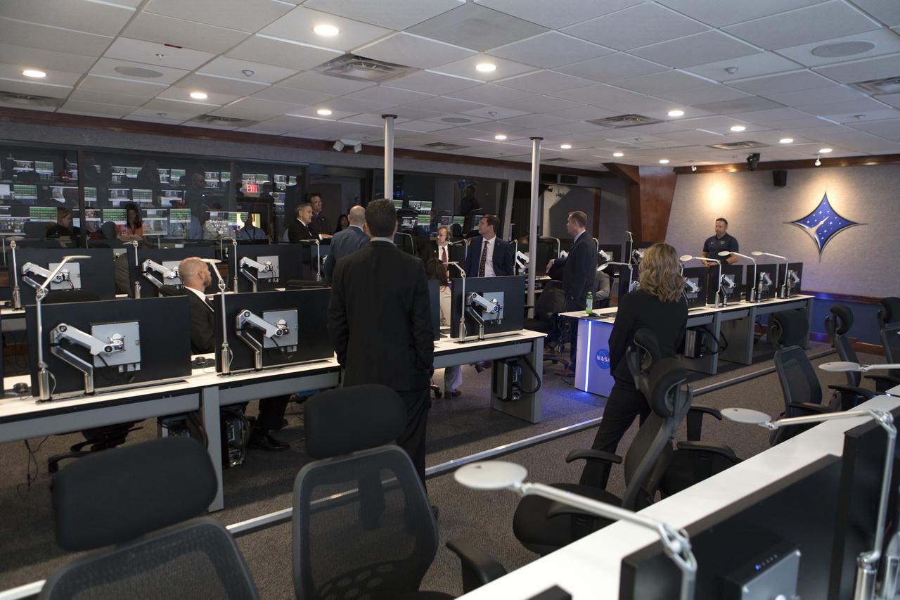 NASA Administrator Jim Bridenstine, third row from front, second from right, tours the Launch Services Program's Mission Director's Center in Hangar AE, on Aug. 7, 2018, at Cape Canaveral Air Force Station in Florida. Kennedy Space Center Director Bob Cabana, first row up front, center, updates the administrator on LSP missions and accomplishments.