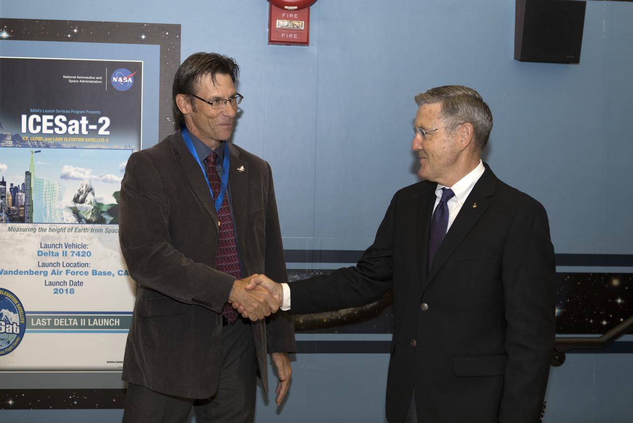 NASA Kennedy Space Center Director Bob Cabana, at right, congratulates Chuck Dovale, deputy program manager for the Launch Services Program (LSP), on Aug. 7, 2018. During a visit to the center, NASA Administrator Jim Bridenstine presents a NASA Distinguished Service Medal to Dovale. During his tour of Hangar AE and LSP's Mission Director's Center, Bridenstine received updates on LSP missions and accomplishments.