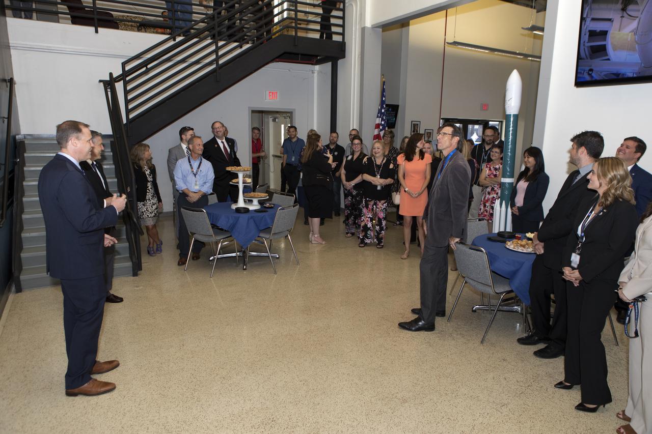 NASA Administrator Jim Bridenstine, left, tours Hangar AE and the Launch Services Program's (LSP) Mission Director's Center at Cape Canaveral Air Force Station in Florida on Aug. 7, 2018. Bridenstine spoke to workers and received updates on LSP missions and accomplishments. At right, standing near a chair, is Chuck Dovale, deputy program manager for LSP. Bridenstine presented a NASA Distinguished Service Medal to Dovale.
