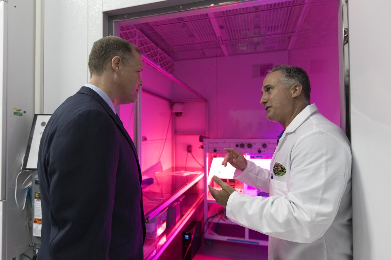 NASA Administrator Jim Bridenstine, at left, tours the Space Station Processing Facility at NASA's Kennedy Space Center in Florida, on Aug. 7, 2018. At right, Trent Smith, Veggie project manager, provides an update on the Veggie plant growth system on the International Space Station, and the control system in the laboratory. Bridenstine also received updates on research and technology accomplishments.