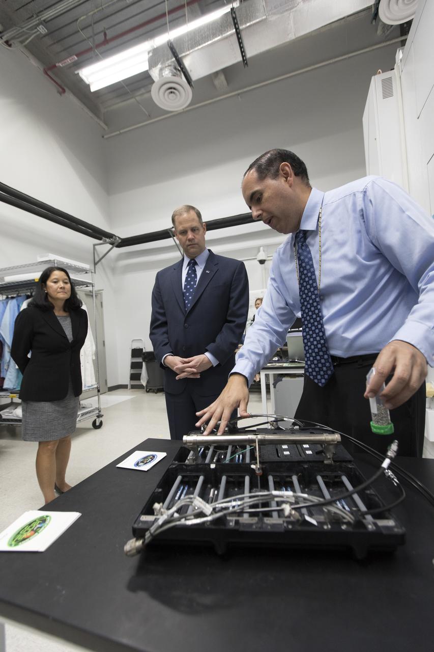 NASA Administrator Jim Bridenstine, center, tours the Space Station Processing Facility at NASA's Kennedy Space Center in Florida, on Aug. 7, 2018. At right, Bryan Onate, Advanced Plant Habitat (APH) project manager, explains a component of the APH cooling system. At left is Josie Burnett, director of Exploration Research and Technology. Bridenstine also received updates on research and technology accomplishments.