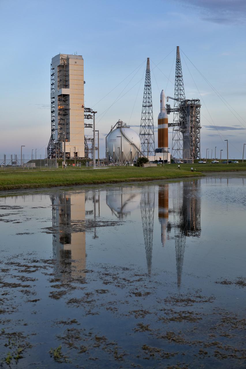 On Friday, Aug. 10, 2018, at Cape Canaveral Air Force Station in Florida, the United Launch Alliance Delta IV Heavy rocket that will boost NASA's Parker Solar Probe is reflected in a nearby pond during rollback of the Mobile Service Tower gantry at Space Launch Complex 37. Parker Solar Probe will perform the closest-ever observations of a star when it travels through the Sun's atmosphere, called the corona. The probe will rely on measurements and imaging to revolutionize our understanding of the corona and the Sun-Earth connection.
