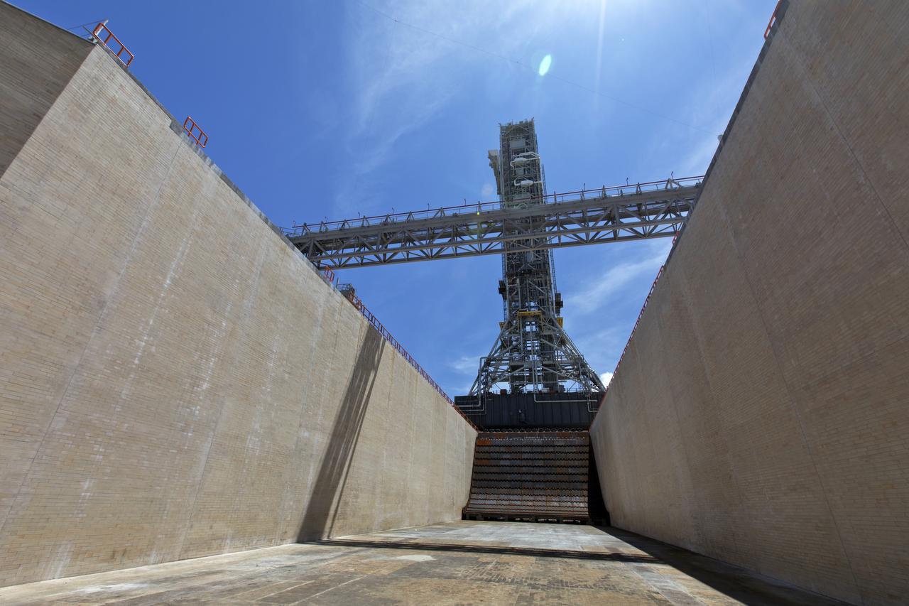 With a view of the flame trench and flame deflector below, NASA's mobile launcher (ML) atop crawler-transporter 2 arrives at Launch Pad 39B on Aug. 31, 2018, at the agency's Kennedy Space Center in Florida. The ML will undergo a fit check, followed by several days of systems testing. The 380-foot-tall mobile launcher is equipped with the crew access arm and several umbilicals that will provide power, environmental control, pneumatics, communication and electrical connections to NASA's Space Launch System (SLS) and Orion spacecraft. Exploration Ground Systems is preparing the ground systems necessary to launch SLS and Orion on Exploration Mission-1, missions to the Moon and on to Mars.