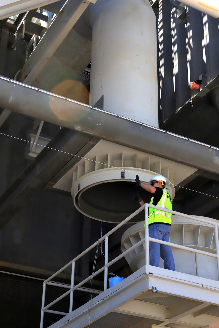 A technician watches as the ignition overpressure water system pipe on the mobile launcher slowly aligns with the pipe on the ground system at Launch Pad 39B at NASA's Kennedy Space Center in Florida, on Aug. 31, 2018. The ML, atop crawler-transporter 2, made the trek along the crawlerway to the pad for a fit check and several days of systems testing. The 380-foot-tall mobile launcher is equipped with the crew access arm and several umbilicals that will provide power, environmental control, pneumatics, communication and electrical connections to NASA's Space Launch System (SLS) and Orion spacecraft. Exploration Ground Systems is preparing the ground systems necessary to launch SLS and Orion on Exploration Mission-1, missions to the Moon and on to Mars.