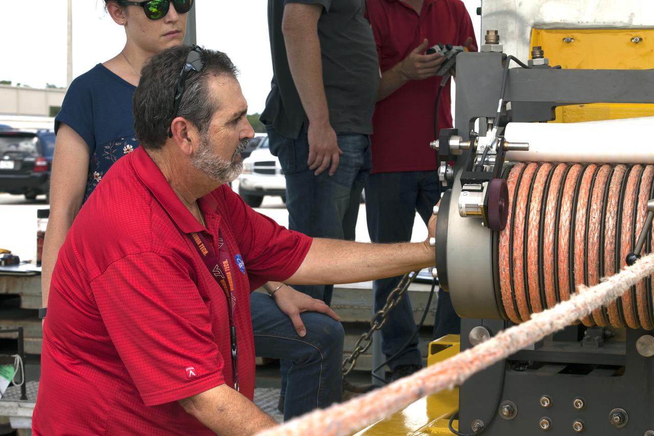 Orion Landing and Recovery team members with Jacobs practice using a winch to prepare for Underway Recovery Test 7 (URT-7) on Sept. 5, 2018, in the heavy equipment yard at NASA's Kennedy Space Center in Florida. In front is Pete Ruett. Behind him is Amy Hein. Both are handling and access engineers. During URT-7, the recovery team, including Exploration Ground Systems and the U.S. Navy, will practice recovering a test version of the Orion crew module in the Pacific Ocean, off the coast of California, and guiding it into the well deck of a ship. Over several days, the team will demonstrate and evaluate new recovery processes, procedures, hardware and personnel in open waters. Orion is the exploration spacecraft designed to carry astronauts to deep space destinations, including the Moon and on to Mars. Orion will have emergency abort capability, sustain the crew during space travel and provide safe re-entry from deep space return velocities.