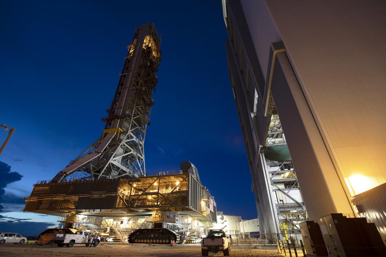 NASA's mobile launcher, atop crawler-transporter 2, is at the entrance to High Bay 3 at the Vehicle Assembly Building (VAB) just before sunrise on Sept. 8, 2018, at NASA's Kennedy Space Center in Florida. The mobile launcher departed Launch Pad 39B after several days of testing with the pad. This is the first time that the modified mobile launcher made the trip to the pad and the VAB. The mobile launcher will spend seven months in the VAB undergoing testing. The 380-foot-tall structure is equipped with the crew access arm and several umbilicals that will provide power, environmental control, pneumatics, communication and electrical connections to the agency's Space Launch System and Orion spacecraft. Exploration Ground Systems is preparing the ground systems necessary to launch SLS and Orion on Exploration Mission-1, missions to the Moon and on to Mars.