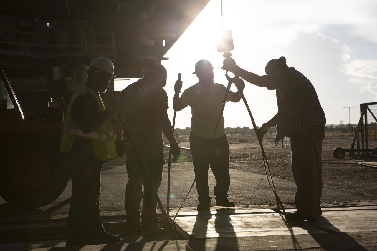 Technicians remove special planks covering tracks as NASA's mobile launcher, atop crawler-transporter 2, moves into High Bay 3 at the Vehicle Assembly Building (VAB) on Sept. 8, 2018, at NASA's Kennedy Space Center in Florida. The mobile launcher departed Launch Pad 39B after several days of testing with the pad. This is the first time that the modified mobile launcher made the trip to the pad and the VAB. The mobile launcher will spend seven months in the VAB undergoing testing. The 380-foot-tall structure is equipped with the crew access arm and several umbilicals that will provide power, environmental control, pneumatics, communication and electrical connections to the agency's Space Launch System and Orion spacecraft. Exploration Ground Systems is preparing the ground systems necessary to launch SLS and Orion on Exploration Mission-1, missions to the Moon and on to Mars.