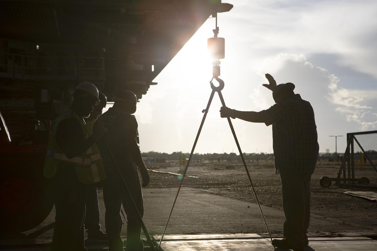 Technicians remove special planks covering tracks as NASA's mobile launcher, atop crawler-transporter 2, moves into High Bay 3 at the Vehicle Assembly Building (VAB) on Sept. 8, 2018, at NASA's Kennedy Space Center in Florida. The mobile launcher departed Launch Pad 39B after several days of testing with the pad. This is the first time that the modified mobile launcher made the trip to the pad and the VAB. The mobile launcher will spend seven months in the VAB undergoing testing. The 380-foot-tall structure is equipped with the crew access arm and several umbilicals that will provide power, environmental control, pneumatics, communication and electrical connections to the agency's Space Launch System and Orion spacecraft. Exploration Ground Systems is preparing the ground systems necessary to launch SLS and Orion on Exploration Mission-1, missions to the Moon and on to Mars.