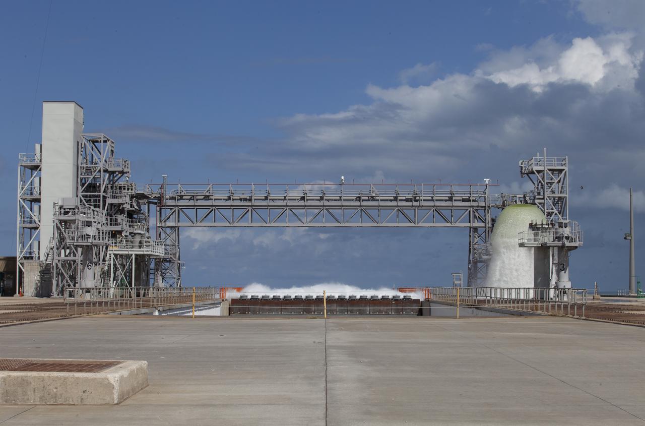 A flow test of the Ignition Overpressure Protection and Sound Suppression water deluge system begins at Launch Pad 39B at NASA's Kennedy Space Center in Florida, on Oct. 15, 2018. At peak flow, the water will reach about 100 feet in the air above the pad surface. It will flow at high speed from a holding tank through new and modified piping and valves, the flame trench, flame deflector nozzles and mobile launcher interface risers. The testing is part of Exploration Ground System's preparation for the new Space Launch System rocket. Modifications were made to the pad after a previous wet flow test, increasing the performance of the system. During the launch of Exploration Mission-1 and subsequent missions, this water deluge system will release about 450,000 gallons of water across the mobile launcher and Flame Deflector to reduce the extreme heat and energy generated by the rocket during ignition and liftoff.