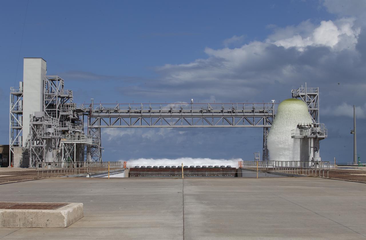 A flow test of the Ignition Overpressure Protection and Sound Suppression water deluge system is in progress at Launch Pad 39B at NASA's Kennedy Space Center in Florida, on Oct. 15, 2018. At peak flow, the water will reach about 100 feet in the air above the pad surface. It will flow at high speed from a holding tank through new and modified piping and valves, the flame trench, flame deflector nozzles and mobile launcher interface risers. The testing is part of Exploration Ground System's preparation for the new Space Launch System rocket. Modifications were made to the pad after a previous wet flow test, increasing the performance of the system. During the launch of Exploration Mission-1 and subsequent missions, this water deluge system will release about 450,000 gallons of water across the mobile launcher and Flame Deflector to reduce the extreme heat and energy generated by the rocket during ignition and liftoff.