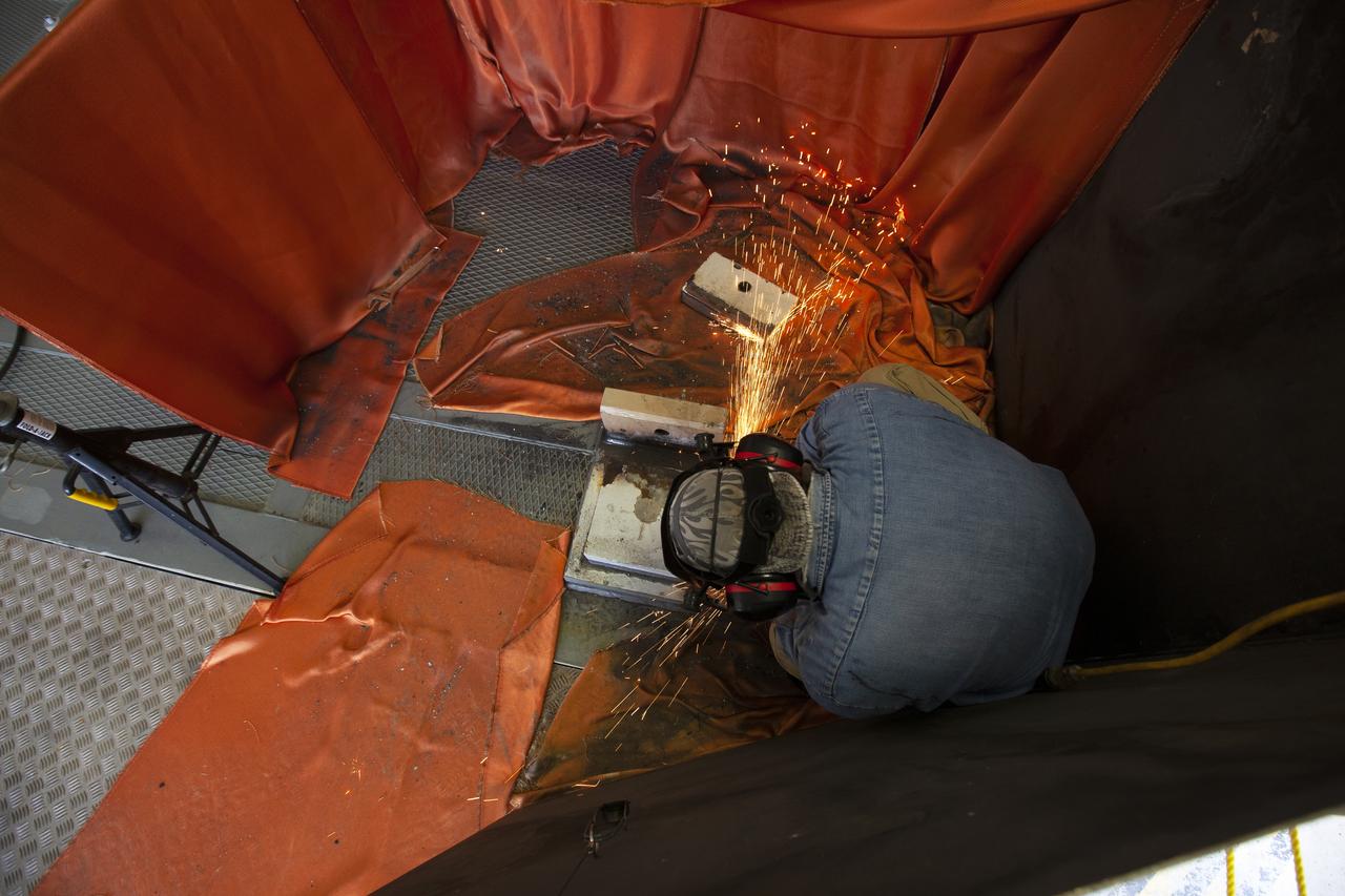 A Jacobs technician from the Launch Equipment Shop performs welding on the KAMAG spacecraft transporter on Oct. 26, 2018, inside a facility at the crawler yard at NASA’s Kennedy Space Center in Florida. The transporter is designed to carry heavy loads. Welding is being performed on the attach points that will hold the Orion transportation pallet in place. Testing of the pallet will be performed to support validation and verification of the attach fittings in the Multi-Payload Processing Facility.