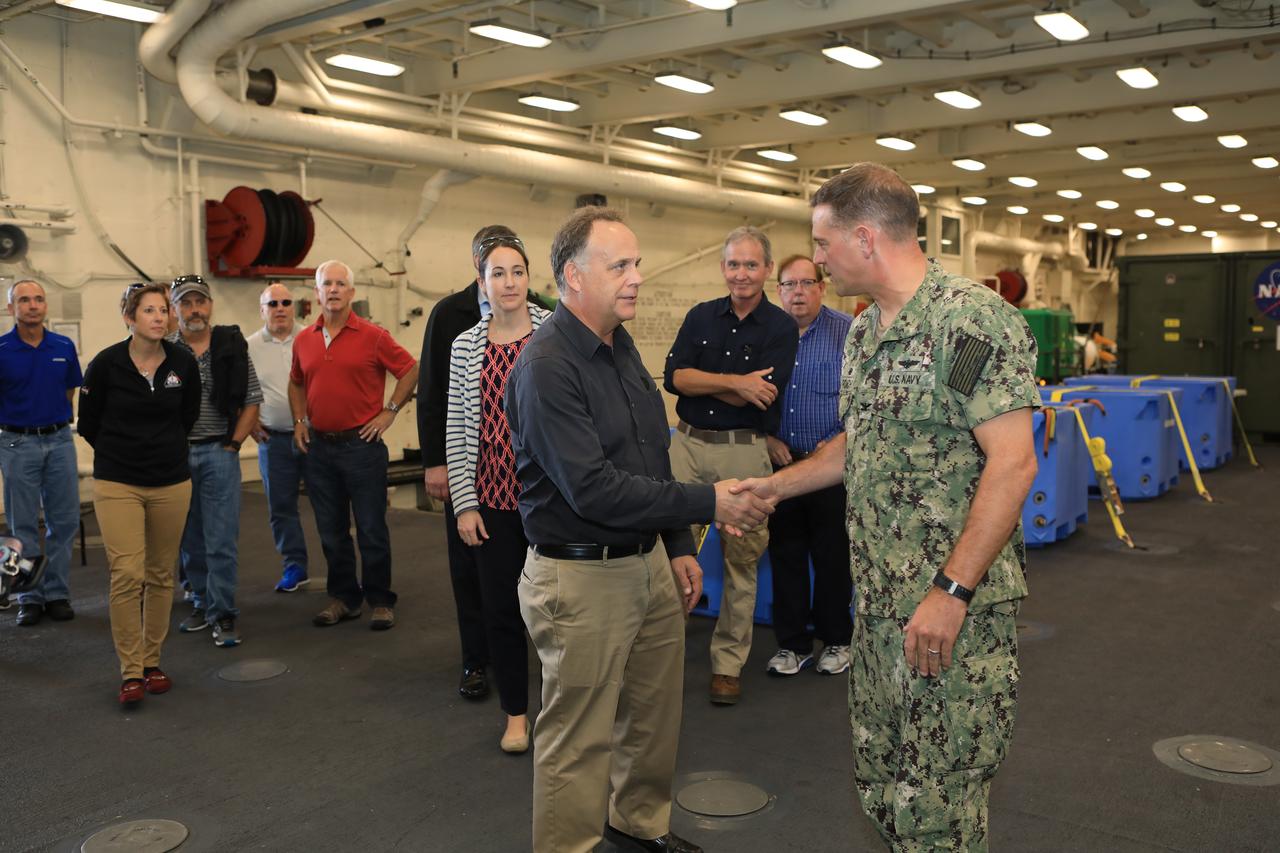 Captain Anthony Roach, at right, commanding officer in the U.S. Navy, welcomes Shawn Quinn and other senior leaders from around NASA onto his ship on Oct. 29, 2018. The visit is a familiarization tour coordinated by the Exploration Ground Systems (EGS) recovery team as they prepare for Underway Recovery Test-7 (URT-7). EGS and the U.S. Navy will use a test version of the Orion crew module, several rigid hull inflatable boats and support equipment to verify and validate processes, procedures, hardware and personnel during recovery of Orion in open waters. URTs are a series of tests to ensure all systems are go when recovering the Orion crew capsule and astronauts onboard in the future. Orion will have emergency abort capability, sustain the crew during space travel and provide safe re-entry from deep space return velocities.
