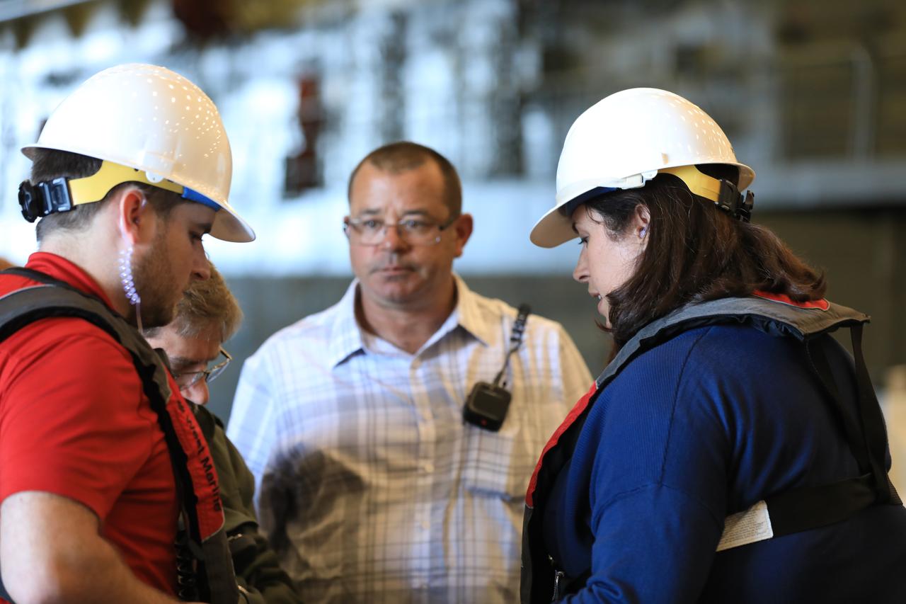 Inside a U.S. Navy ship, Exploration Ground Systems (EGS) Landing and Recovery Director Melissa Jones, at right, briefs her team on Oct. 30, 2018, before they begin Underway Recovery Test-7 (URT-7). EGS and the U.S. Navy will use a test version of the Orion crew module, several rigid hull inflatable boats and support equipment to verify and validate processes, procedures, hardware and personnel during recovery of Orion in open waters. URT-7 is one in a series of tests to verify and validate procedures and hardware that will be used to recover the Orion spacecraft after it splashes down in the Pacific Ocean following deep space exploration missions. Orion will have emergency abort capability, sustain the crew during space travel and provide safe re-entry from deep space return velocities.