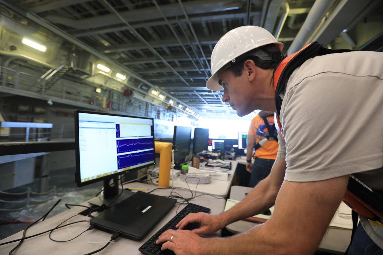 Benjamin Connell, a principal scientist with Applied Physical Sciences, monitors wave movement inside the well deck of a U.S. Navy ship during Underway Recovery Test-7 (URT-7) on Oct. 30, 2018. The Exploration Ground Systems (EGS) recovery team and the U.S. Navy will use a test version of the Orion crew module, several rigid hull inflatable boats and support equipment to verify and validate processes, procedures, hardware and personnel during recovery of Orion in open waters. The testing is one in a series of tests to verify and validate procedures and hardware that will be used to recover the Orion spacecraft after it splashes down in the Pacific Ocean following deep space exploration missions. Orion will have emergency abort capability, sustain the crew during space travel and provide safe re-entry from deep space return velocities.