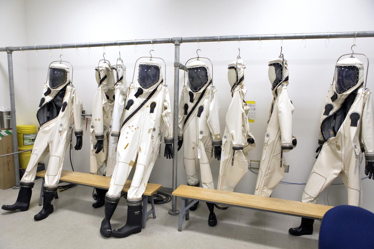 Technicans inside Kennedy's Multi-Payload Processing Facility do testing in SCAPE (Self-Contained Atmospheric Protective Ensemble) suits.