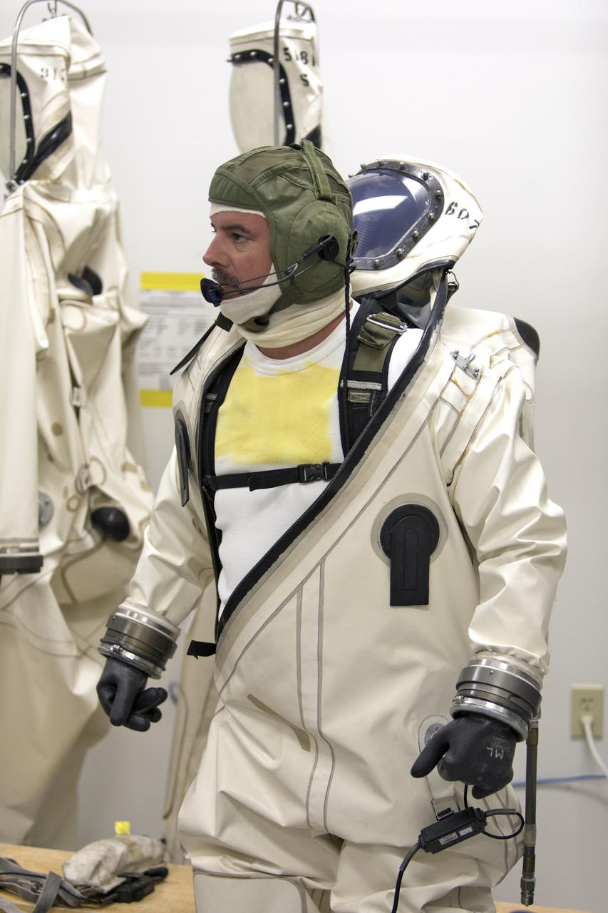 Technicans inside Kennedy's Multi-Payload Processing Facility do testing in SCAPE (Self-Contained Atmospheric Protective Ensemble) suits.