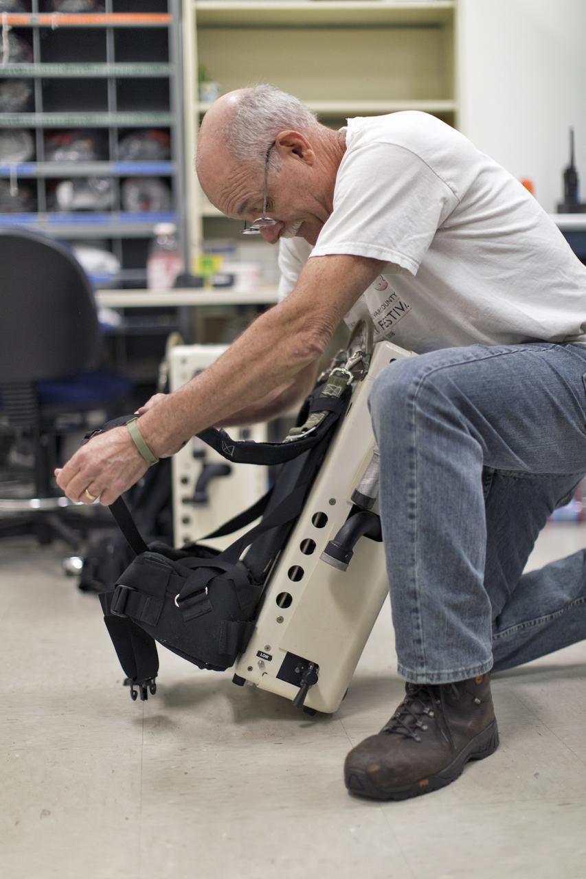 Technicans inside Kennedy's Multi-Payload Processing Facility do testing in SCAPE (Self-Contained Atmospheric Protective Ensemble) suits.
