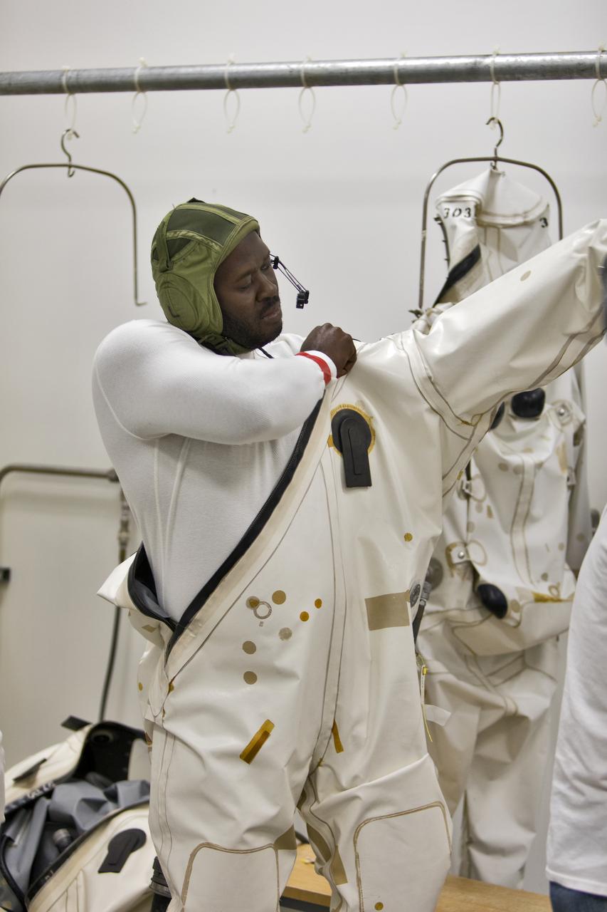 Technicans inside Kennedy's Multi-Payload Processing Facility do testing in SCAPE (Self-Contained Atmospheric Protective Ensemble) suits.