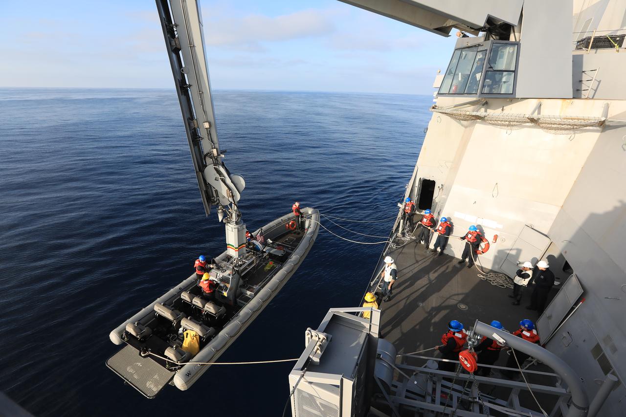 Small boats used by U.S. Navy divers are lowered into the water in preparation for the dive teams to race out to a test version of the Orion capsule during Underway Recovery Test-7 (URT-7), on Oct. 31, 2018, aboard the USS John P. Murtha in the Pacific Ocean. The Exploration Ground Systems (EGS) Landing and Recovery team and the U.S. Navy are using the mock Orion, several rigid hull inflatable boats and support equipment to verify and validate processes, procedures, hardware and personnel during recovery of Orion in open waters. URT-7 is one in a series of tests to verify and validate procedures and hardware that will be used to recover the Orion spacecraft after it splashes down in the Pacific Ocean following deep space exploration missions. Orion will have emergency abort capability, sustain the crew during space travel and provide safe re-entry from deep space return velocities.