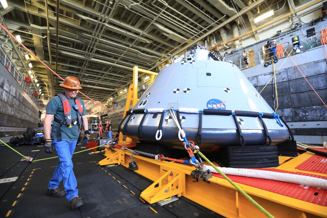 Travis Methany, with Jacobs, prepares the test version of the Orion capsule for release in the well deck of the USS John P. Murtha, during Underway Recovery Test-7 (URT-7) on Oct. 31, 2018, in the Pacific Ocean. Exploration Ground Systems and the U.S. Navy are using the mock Orion to verify and validate processes, procedures, hardware and personnel during recovery of Orion in open waters. URTs are a series of tests to verify and validate procedures and hardware that will be used to recover the Orion spacecraft after it splashed down in the Pacific Ocean following deep space exploration missions. Orion will have emergency abort capability, sustain the crew during space travel and provide safe re-entry from deep space return velocities.