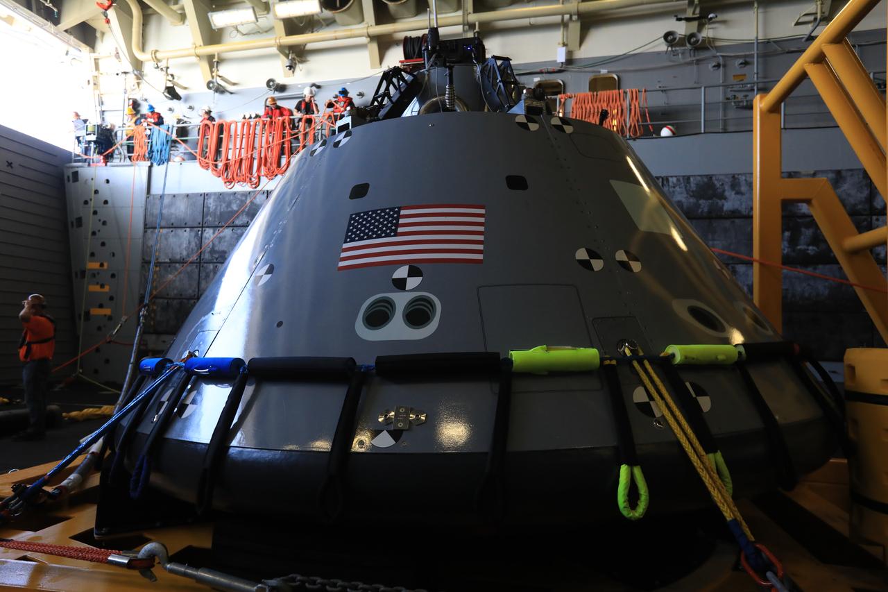 A test version of the Orion capsule sits in its cradle in the well deck of the USS John P. Murtha during Underway Recovery Test-7 (URT-7) on Oct. 31, 2018. The Exploration Ground Systems recovery team and the U.S. Navy are using a test version of the Orion crew module, several rigid hull inflatable boats and support equipment to verify and validate processes, procedures, hardware and personnel during recovery of Orion in open waters. The test is one in a series of tests to verify and validate procedures and hardware that will be used to recover the Orion spacecraft after it splashes down in the Pacific Ocean following deep space exploration missions. Orion will have emergency abort capability, sustain the crew during space travel and provide safe re-entry from deep space return velocities.