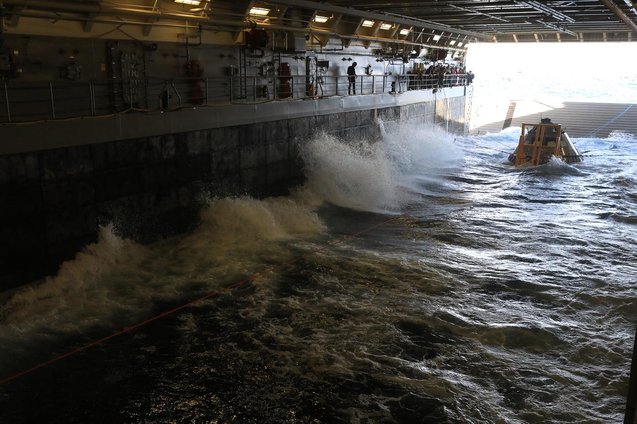 The Exploration Ground Systems Recovery Team, based out of Kennedy Space Center in Florida, practices bringing a test version of the Orion capsule inside the flooded well deck of the USS John P. Murtha and setting it in a cradle as part of Underway Recovery Test-7 (URT-7) on Oct. 31, 2018, in the Pacific Ocean. URT-7 is one in a series of tests to verify and validate procedures and hardware that will be used to recover the Orion spacecraft after it splashes down in the Pacific Ocean following deep space exploration missions. Orion will have emergency abort capability, sustain the crew during space travel and provide safe re-entry from deep space return velocities.