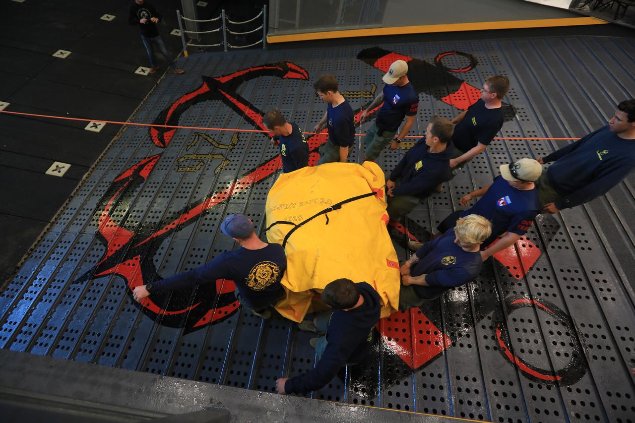 U.S. Navy divers carry the inflatable "front porch" to a small boat during Underway Recovery Test-7 (URT-7) on Nov. 1, 2018. During recovery operations, future astronauts will have the choice to stay in the Orion capsule while it is pulled into the well deck of a U.S. Navy ship, or be pulled out immediately on the front porch until taken by small boat back to the ship. The Exploration Ground Systems recovery team and the U.S. Navy are working together to verify and validate procedures and hardware that will be used to recover the Orion spacecraft after it splashes down in the Pacific Ocean following deep space exploration missions. Orion will have emergency abort capability, sustain the crew during space travel and provide safe re-entry from deep space return velocities.