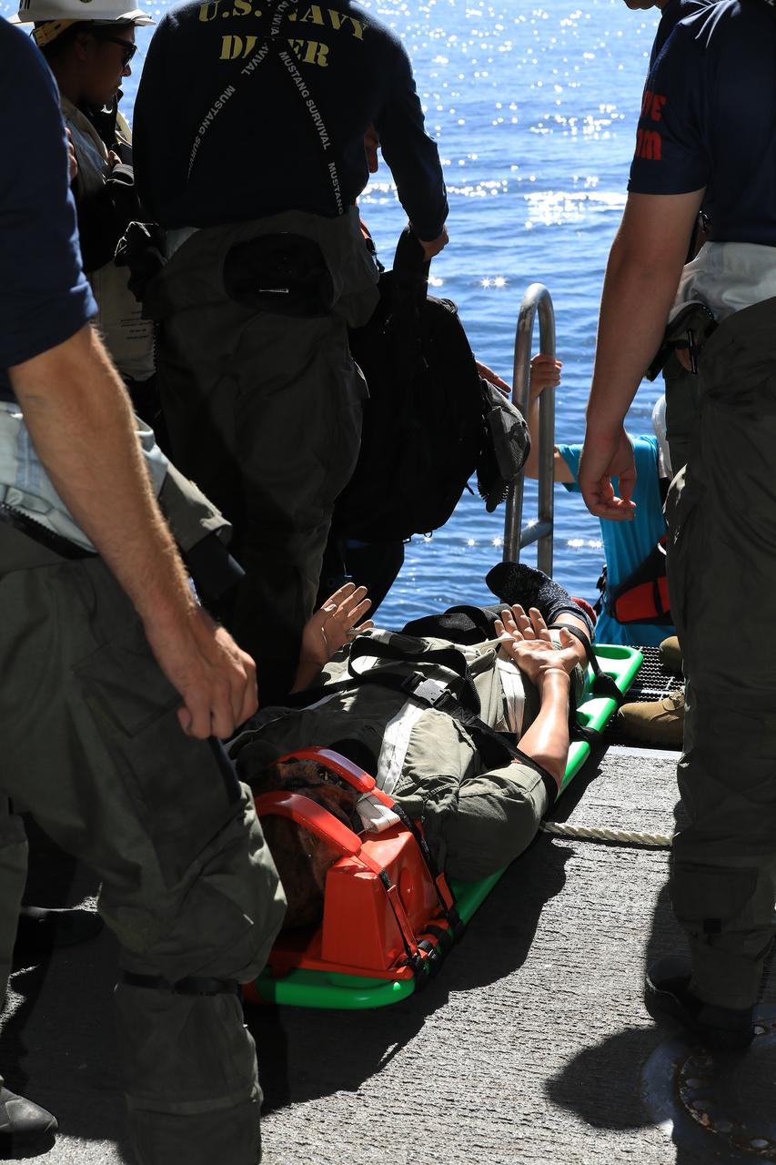 During Underway Recovery Test-7 (URT-7), the crew of the USS John P. Murtha simulate transporting an astronaut from a test version of the Orion capsule onto the ship on Nov. 1, 2018. The test is one in a series of tests to verify and validate procedures and hardware that will be used to recover the Orion spacecraft after it splashes down in the Pacific Ocean following deep space exploration missions. Orion will have emergency abort capability, sustain the crew during space travel and provide safe re-entry from deep space return velocities.