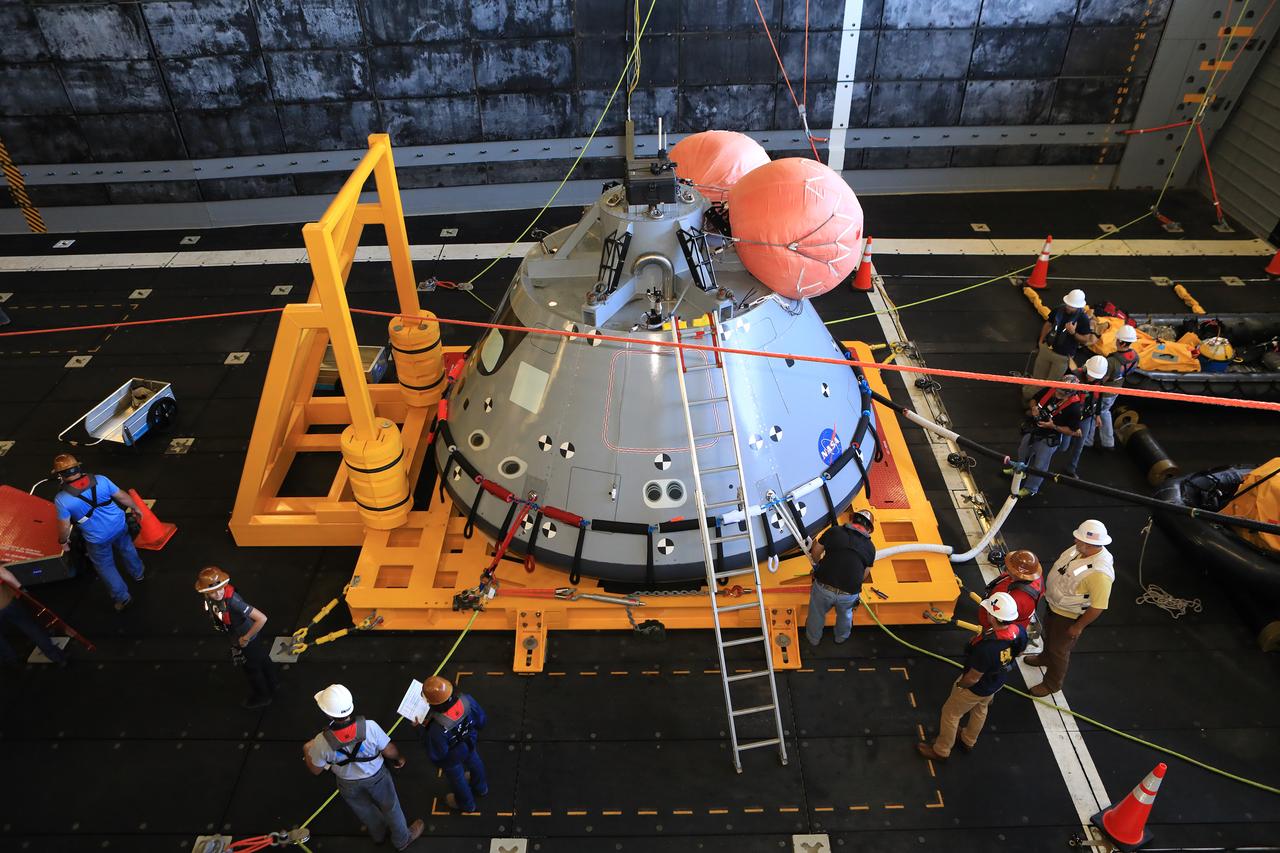 The Exploration Ground Systems (EGS) Recovery Team checks out the test version of the Orion capsule before releasing it into the open water of the Pacific Ocean during Underway Recovery Test-7 (URT-7) on Nov. 1, 2018, on the USS John P. Murtha. There are two large, orange mockup uprighting bags in this view, but when Orion actually splashes down there will be five. The test is one in a series of tests to verify and validate procedures and hardware that will be used to recover the Orion spacecraft after it splashes down in the Pacific Ocean following deep space exploration missions. Orion will have emergency abort capability, sustain the crew during space travel and provide safe re-entry from deep space return velocities.