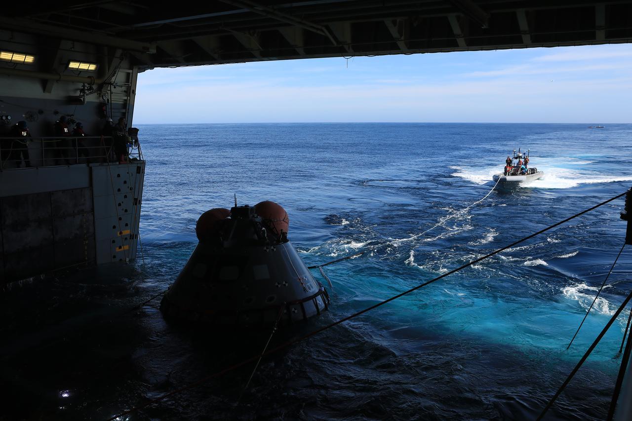 The test version of the Orion capsule is about to be released into the open water as part of Underway Recovery Test-7, aboard the USS. John P. Murtha, on Nov. 1, 2018. During recovery operations, future astronauts aboard Orion will have the choice to stay in the capsule while it is pulled into the well deck of a U.S. Navy ship, or be pulled out immediately and put on the "front porch" until taken by small boat back to the ship. URT-7 is one in a series of tests to verify and validate procedures and hardware that will be used to recover the Orion spacecraft after it splashes down in the Pacific Ocean following deep space exploration missions. Orion will have emergency abort capability, sustain the crew during space travel and provide safe re-entry from deep space return velocities.