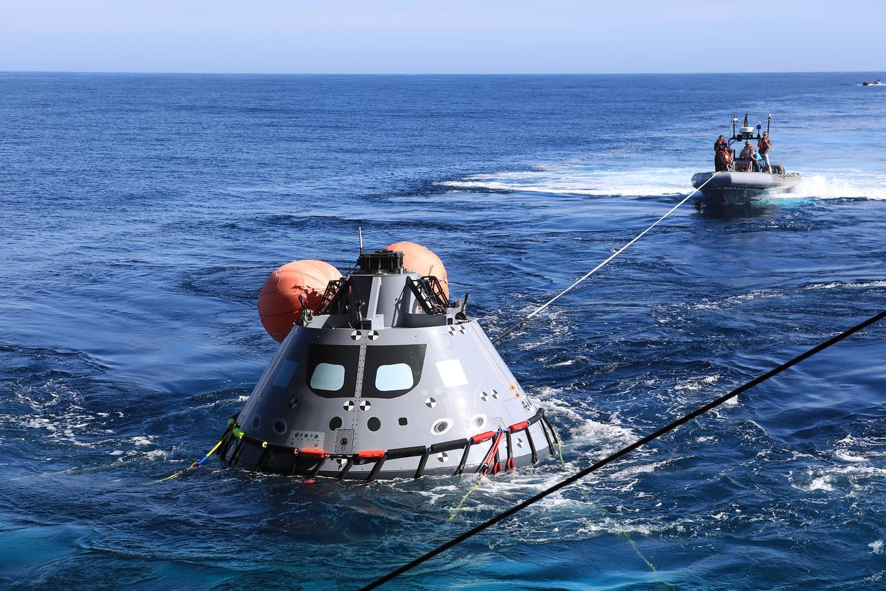 The test version of the Orion capsule is about to be released into the open water as part of Underway Recovery Test-7, aboard the USS. John P. Murtha, on Nov. 1, 2018. During recovery operations, future astronauts aboard Orion will have the choice to stay in the capsule while it is pulled into the well deck of a U.S. Navy ship, or be pulled out immediately and put on the "front porch" until taken by small boat back to the ship. URT-7 is one in a series of tests to verify and validate procedures and hardware that will be used to recover the Orion spacecraft after it splashes down in the Pacific Ocean following deep space exploration missions. Orion will have emergency abort capability, sustain the crew during space travel and provide safe re-entry from deep space return velocities.