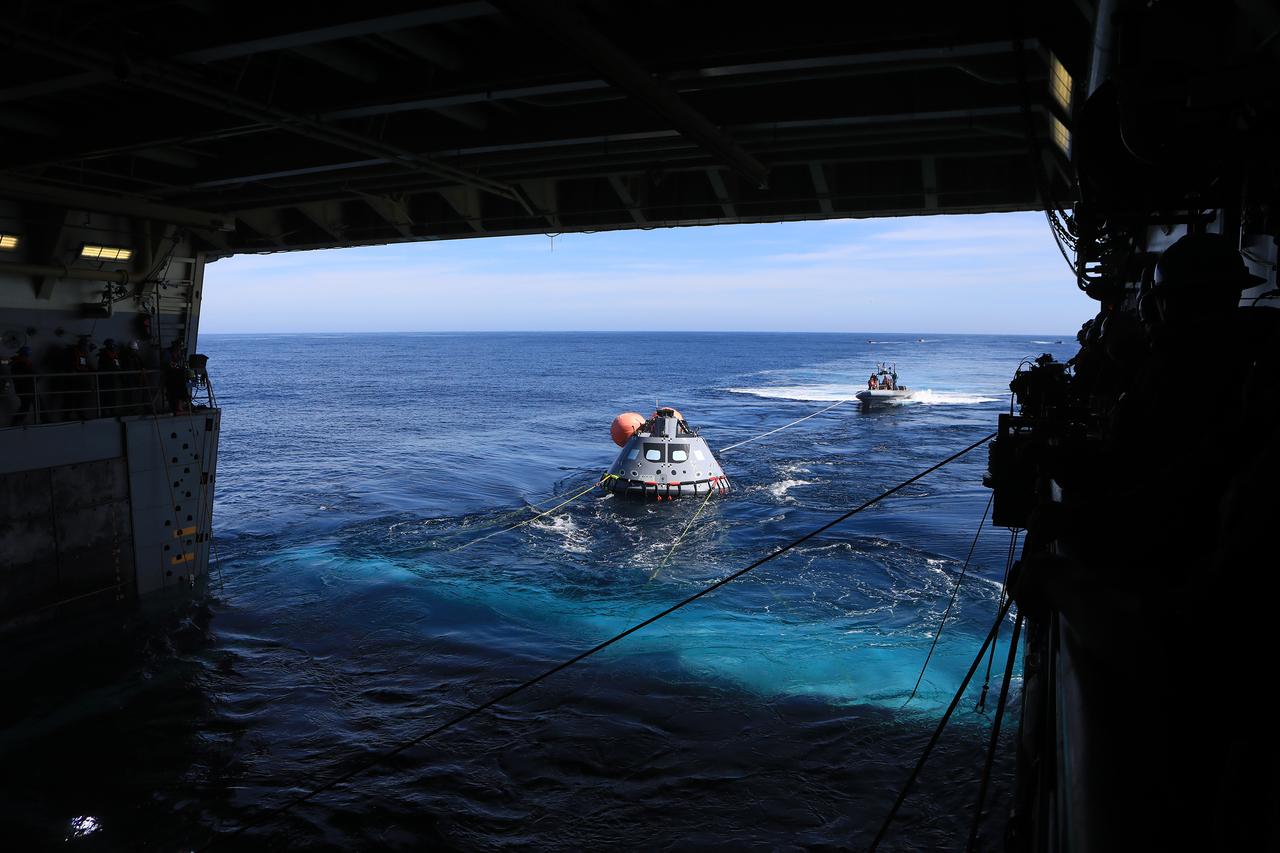 The test version of the Orion capsule is about to be released into the open water as part of Underway Recovery Test-7, aboard the USS. John P. Murtha, on Nov. 1, 2018. During recovery operations, future astronauts aboard Orion will have the choice to stay in the capsule while it is pulled into the well deck of a U.S. Navy ship, or be pulled out immediately and put on the "front porch" until taken by small boat back to the ship. URT-7 is one in a series of tests to verify and validate procedures and hardware that will be used to recover the Orion spacecraft after it splashes down in the Pacific Ocean following deep space exploration missions. Orion will have emergency abort capability, sustain the crew during space travel and provide safe re-entry from deep space return velocities.