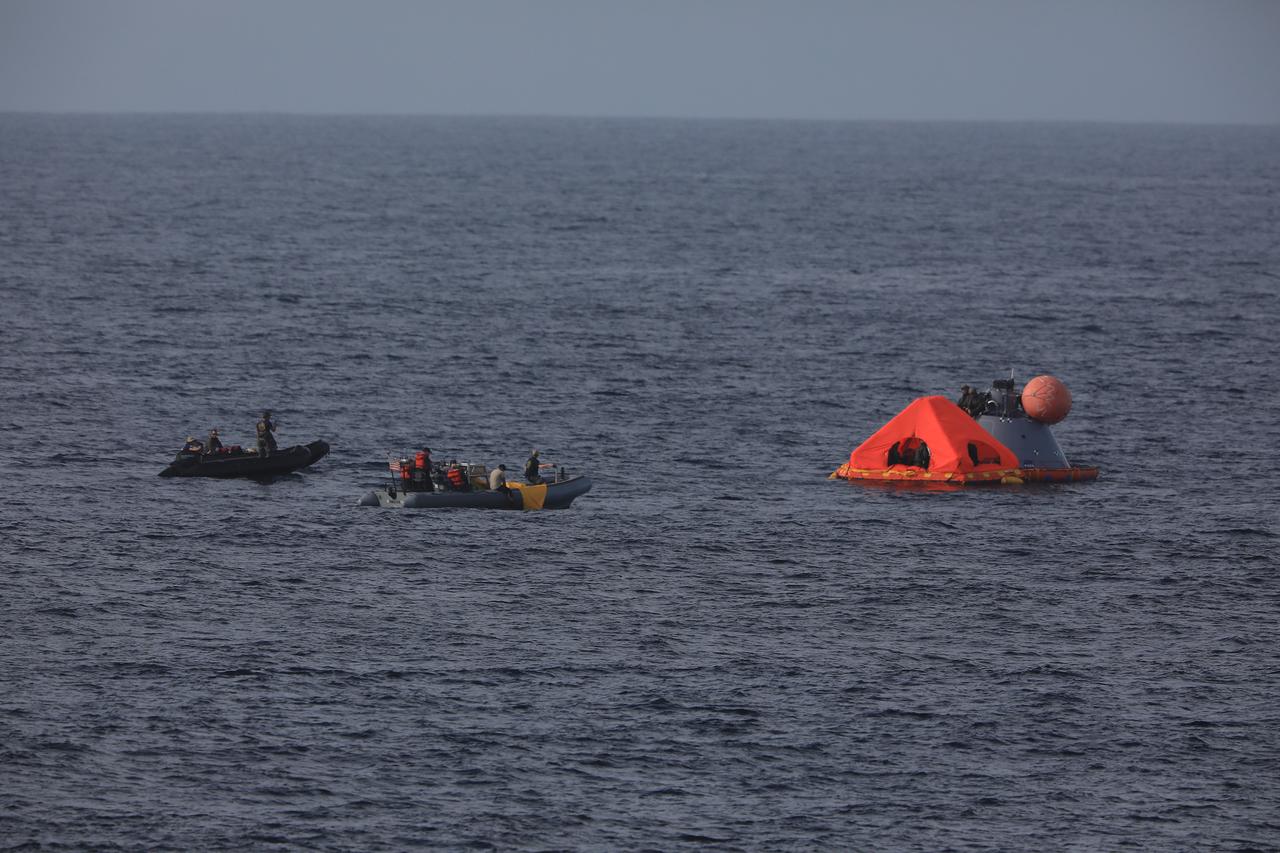 During Underway Recovery Test-7 (URT-7), U.S. Navy divers practice attaching the "front porch" on a test version of the Orion capsule. During recovery operations, future astronauts aboard Orion will have the choice to stay in the capsule while it is pulled into the well deck of a Navy ship, or be pulled out immediately and put on the front porch until taken by small boat back to the ship. URT-7 is one in a series of tests to verify and validate procedures and hardware that will be used to recover the Orion spacecraft after it splashes down in the Pacific Ocean following deep space exploration missions. Orion will have emergency abort capability, sustain the crew during space travel and provide safe re-entry from deep space return velocities.