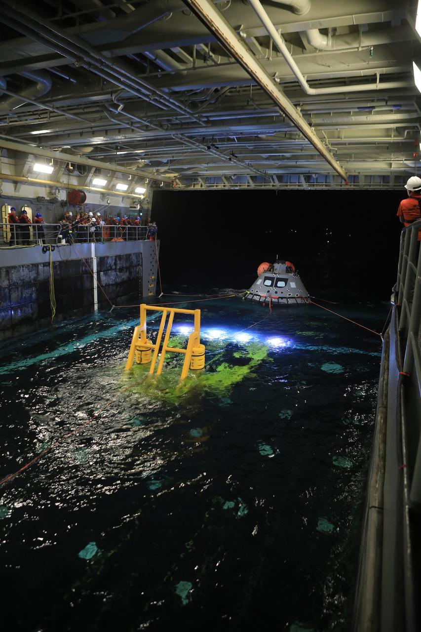 At night, on Nov. 1, 2018, a test version of the Orion capsule is pulled into the well deck of the USS John P. Murtha during Underway Recovery Test-7 (URT) in the Pacific Ocean. URT-7 is one in a series of tests conducted by the Exploration Ground Systems Recovery Team to verify and validate procedures and hardware that will be used to recover the Orion spacecraft after it splashes down in the Pacific Ocean following deep space exploration missions. Orion will have emergency abort capability, sustain the crew during space travel and provide safe re-entry from deep space return velocities.
